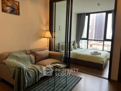 Modern apartment with cozy living room and bedroom, featuring large windows and stylish decor.