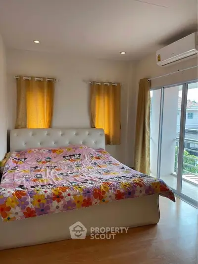 Bright bedroom with large windows and cozy bed, featuring modern decor and natural light.
