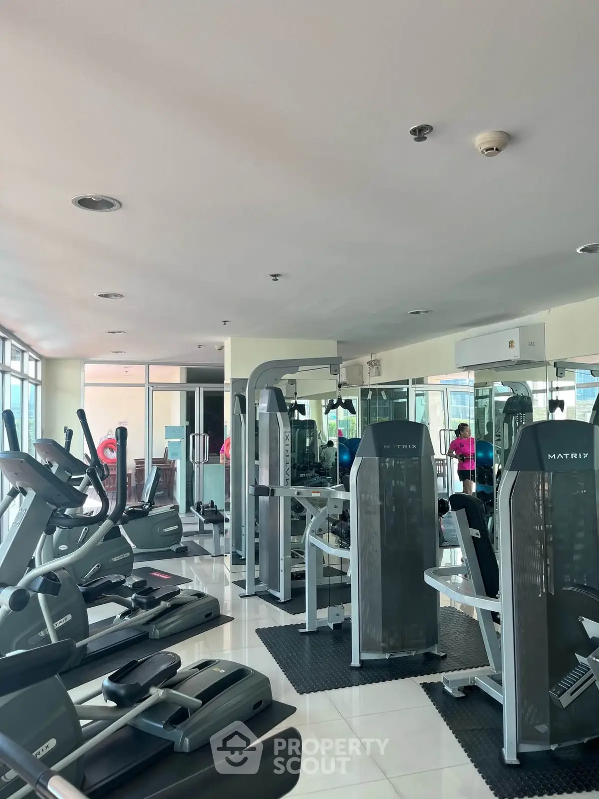 Spacious gym with modern fitness equipment in a well-lit area, ideal for active lifestyle enthusiasts.
