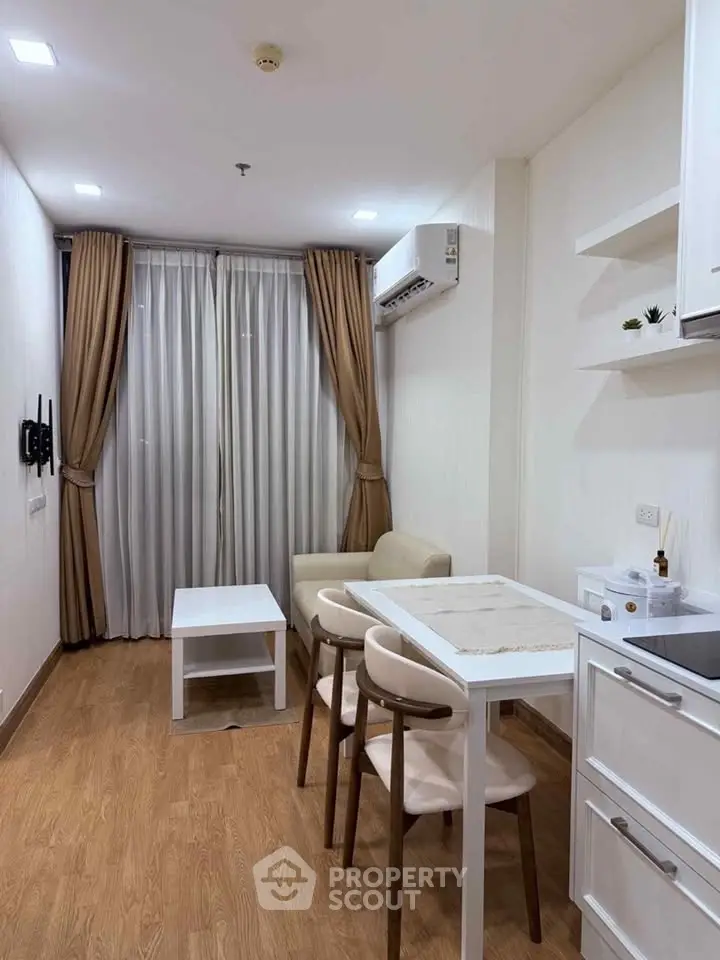 Modern living room with wooden flooring, cozy seating, and elegant curtains in a stylish apartment.