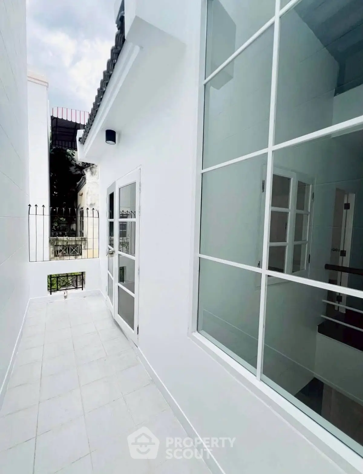 Charming white exterior with modern windows and doors, perfect for a cozy urban retreat.