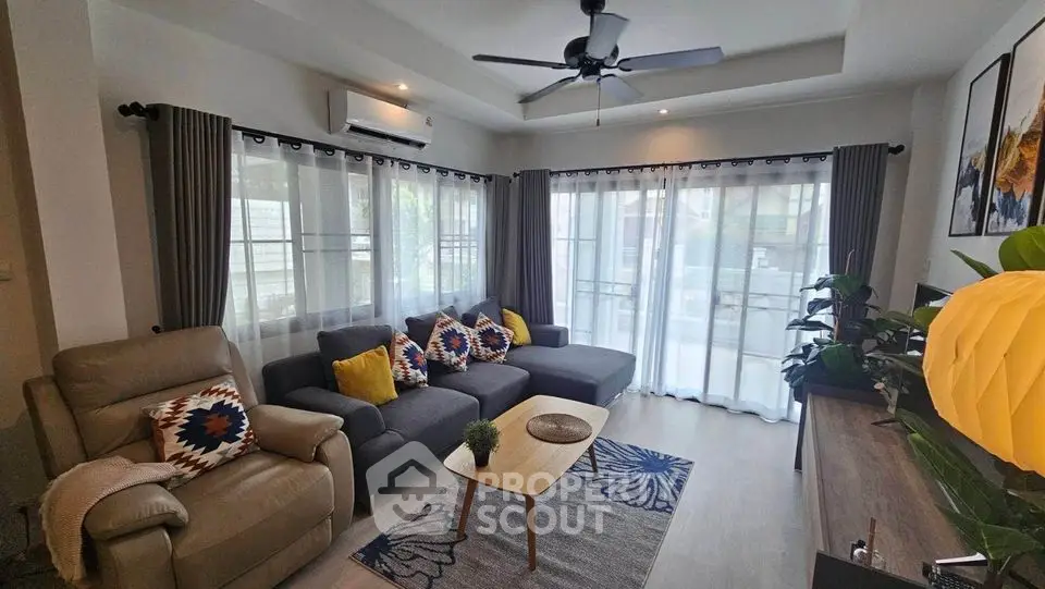 Spacious living room with modern decor and large windows for natural light