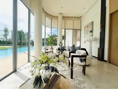 Luxurious living room with pool view, elegant decor, and floor-to-ceiling windows in modern home.
