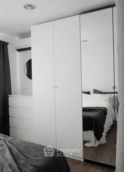 Modern bedroom with sleek white wardrobe and cozy bedding