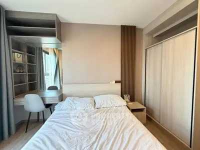 Modern bedroom with stylish decor and built-in wardrobe, featuring a cozy bed and study area.