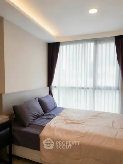 Cozy bedroom with modern design and large windows for natural light.