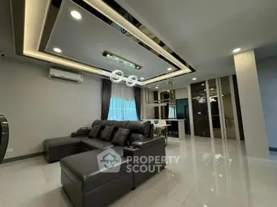 Luxurious modern living room with sleek leather sofa and elegant ceiling lights.
