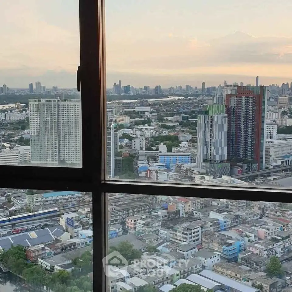 Stunning cityscape view from high-rise apartment window at sunset.