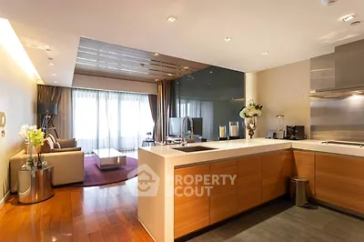 Modern open-layout kitchen and living room with elegant decor and natural light.