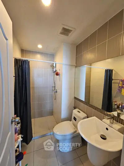 Modern bathroom with shower, toilet, and sink in a compact layout.