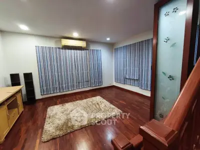 Spacious living room with wooden flooring and modern decor in a stylish home.