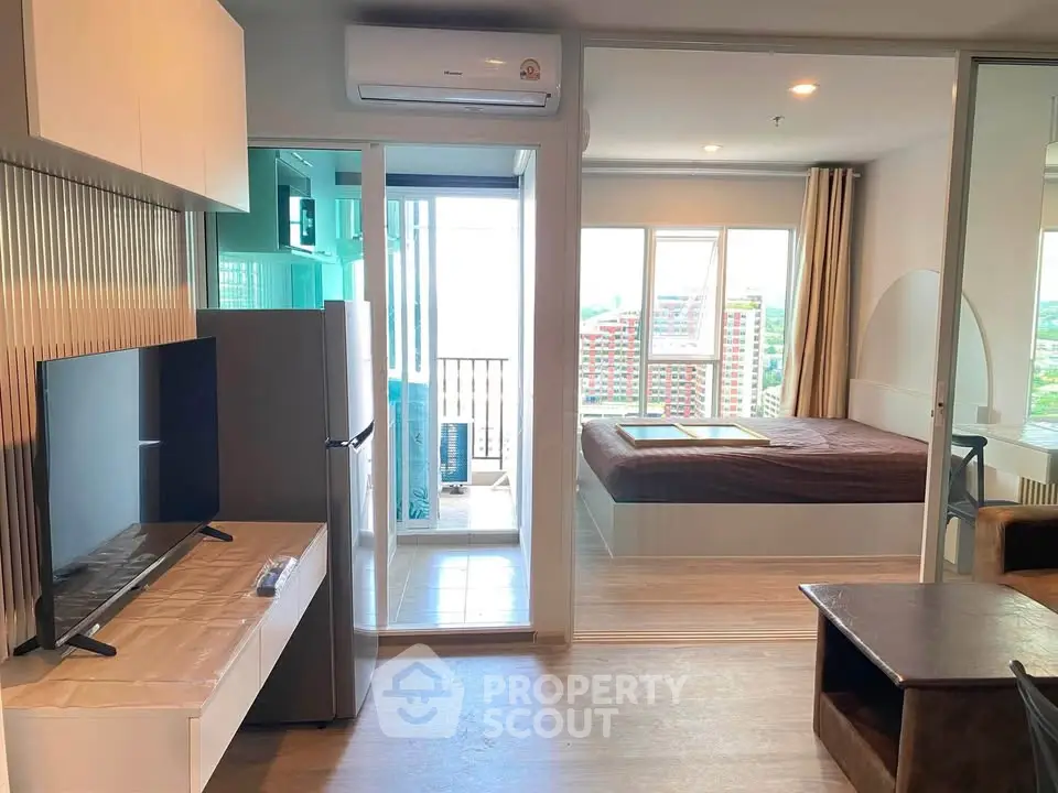 Modern studio apartment with open layout, featuring a cozy living area and bedroom with balcony view.