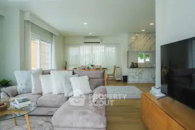 Spacious living room with plush sofa and modern decor, featuring an open layout and natural light.