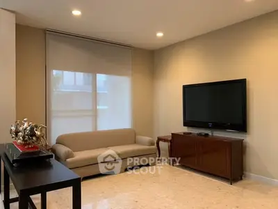 Modern living room with sleek furniture and mounted TV, perfect for relaxation.
