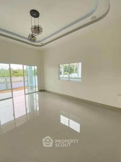 Spacious modern living room with large windows and balcony access