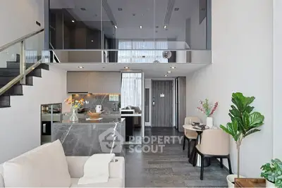 Modern open-plan living room with sleek kitchen and stylish dining area in a contemporary apartment.