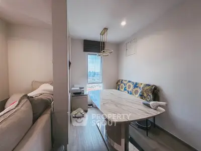Cozy living room with modern dining table and city view window, perfect for urban living.
