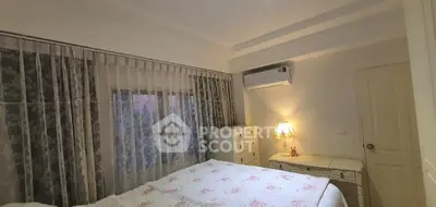 Cozy bedroom with elegant decor and air conditioning, featuring soft lighting and floral curtains.
