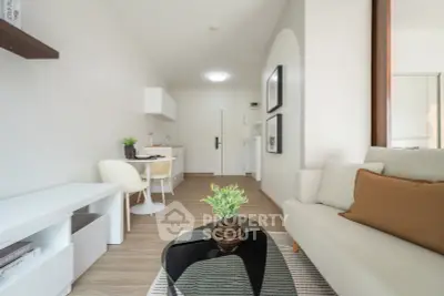 Modern living room with open kitchen, stylish decor, and cozy seating area.