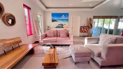 Stylish living room with modern furniture and beach-themed artwork, perfect for relaxation and entertaining.