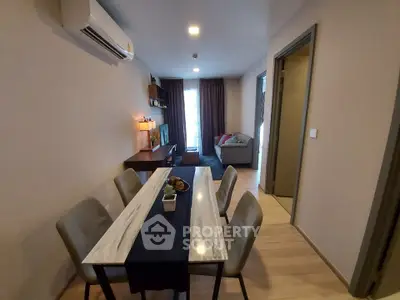 Modern dining area with stylish table and chairs, adjacent to cozy living room with sofa and decor.