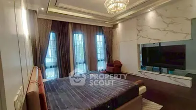 Luxurious bedroom with elegant decor and large windows offering natural light