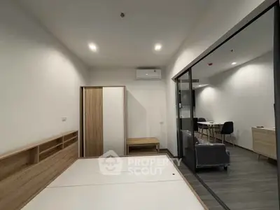 Modern minimalist apartment interior with sleek furniture and glass partition.