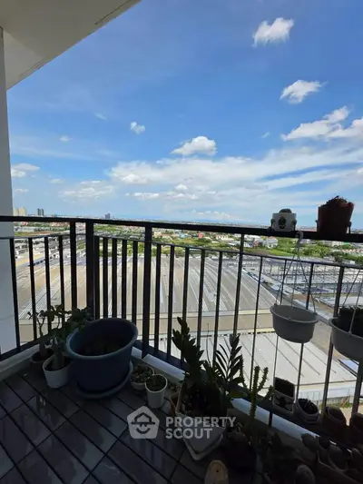 Spacious balcony with stunning city view and potted plants, perfect for relaxation.