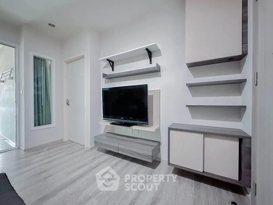 Modern living room with sleek TV unit and minimalist shelving in a stylish apartment.