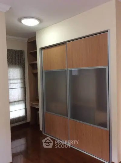Spacious bedroom with built-in wardrobe and wooden flooring