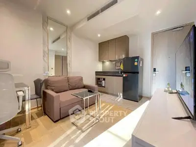 Modern studio apartment with sleek kitchen and cozy living area, featuring stylish furniture and natural light.