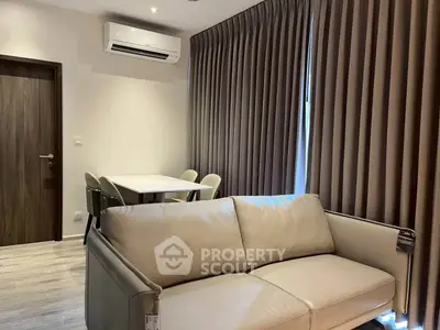 Modern living room with beige sofa, dining table, and air conditioning unit.