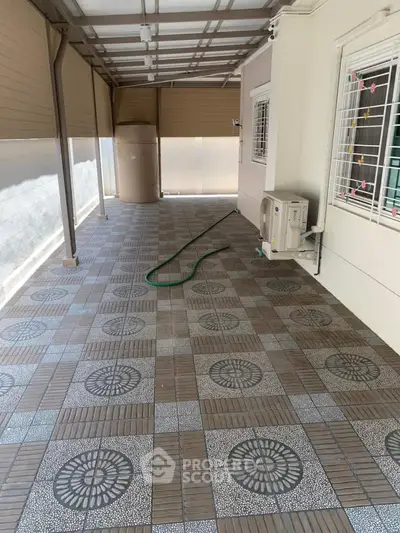 Spacious tiled patio with air conditioning unit and decorative window bars