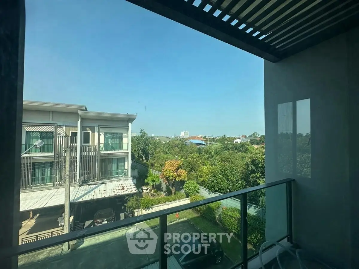 Spacious balcony with scenic view of suburban neighborhood and lush greenery.