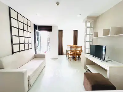 Bright modern living room with dining area, featuring sleek furniture and ample natural light.