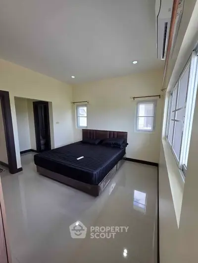 Spacious bedroom with modern decor and ample natural light