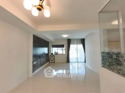 Spacious and bright living room with modern lighting and large windows.