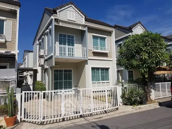 Charming two-story house with modern facade and gated driveway in a serene neighborhood.