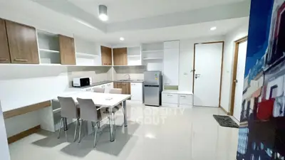 Modern kitchen with sleek cabinets and dining area in contemporary apartment