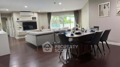 Spacious modern living room with elegant dining area and large windows for natural light.