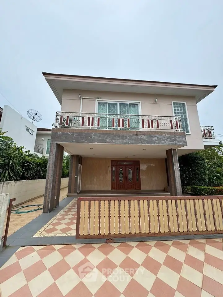 Charming two-story house with spacious balcony and elegant entrance in serene neighborhood.