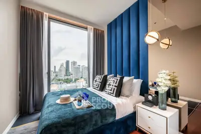 Luxurious bedroom with stunning city view, modern decor, and elegant furnishings in high-rise apartment.