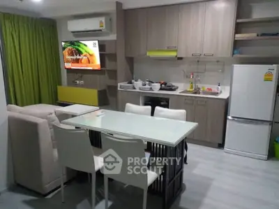 Modern open-layout kitchen and living area with sleek furniture and appliances.