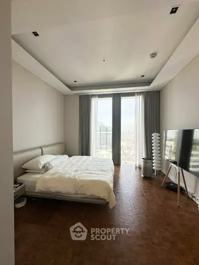 Luxurious bedroom with stunning city view, featuring modern decor and floor-to-ceiling windows.
