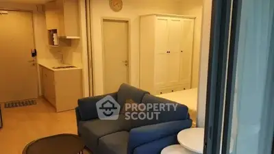 Cozy modern living room with blue sofa and compact kitchen area