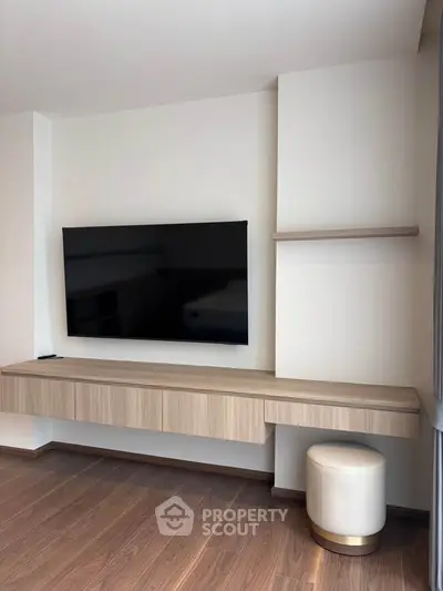 Modern living room with sleek TV unit and wooden flooring