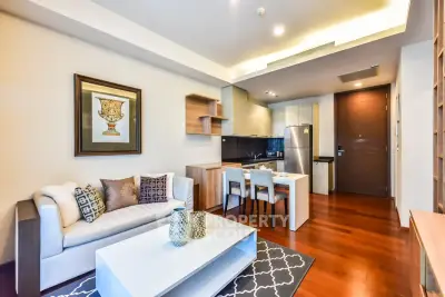 Modern living room with open kitchen, elegant decor, and hardwood floors in a stylish apartment.