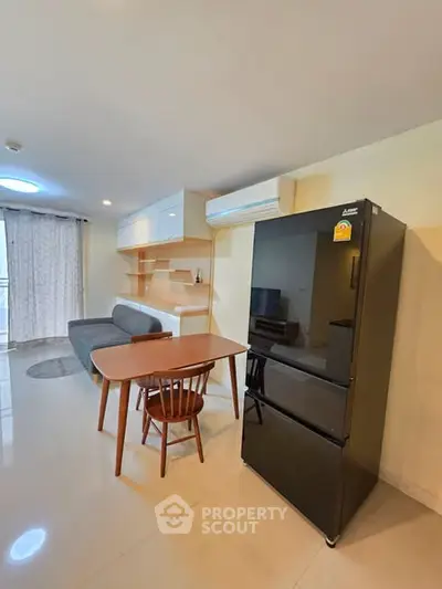Modern living room with sleek furniture and large fridge, perfect for urban living.