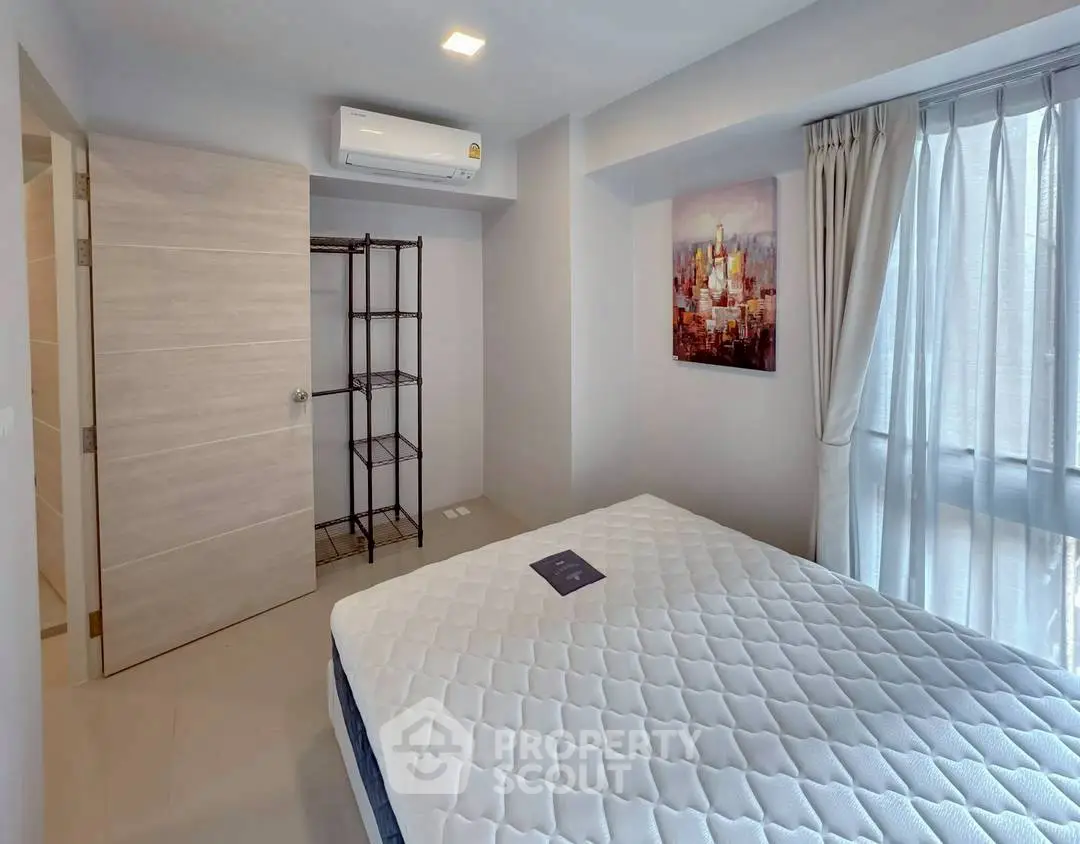 Modern bedroom with large window and air conditioning unit, featuring minimalist decor.