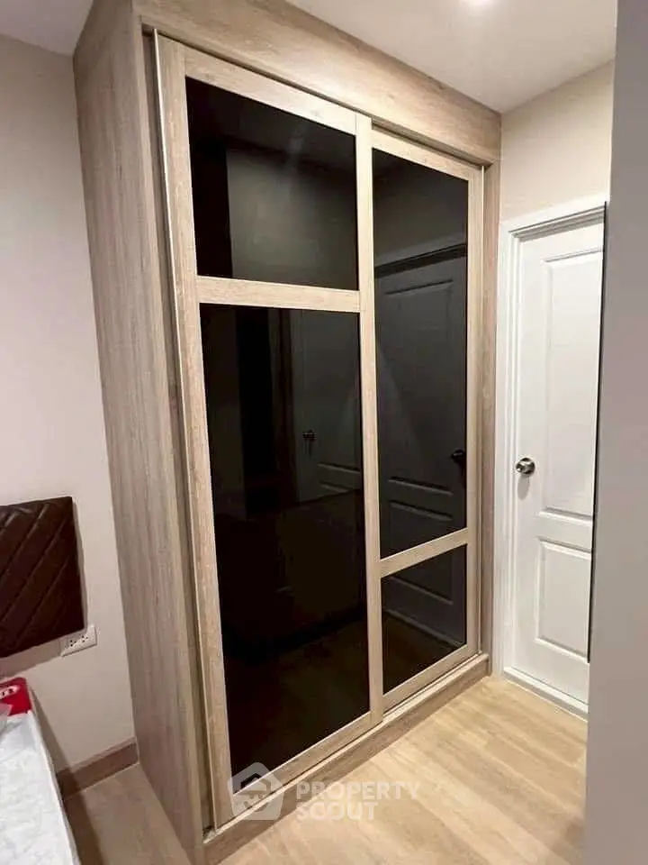 Modern bedroom with sleek built-in wardrobe and elegant wooden flooring.